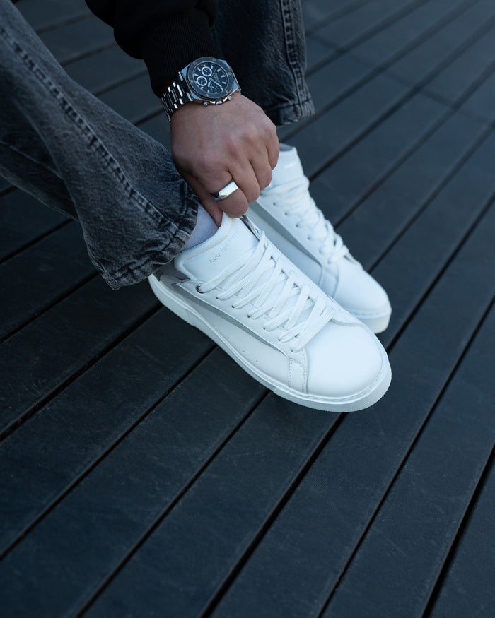 Martin Valen Axino men's white sneakers, top-down view showing laces and gray side stripe, worn and held by hand