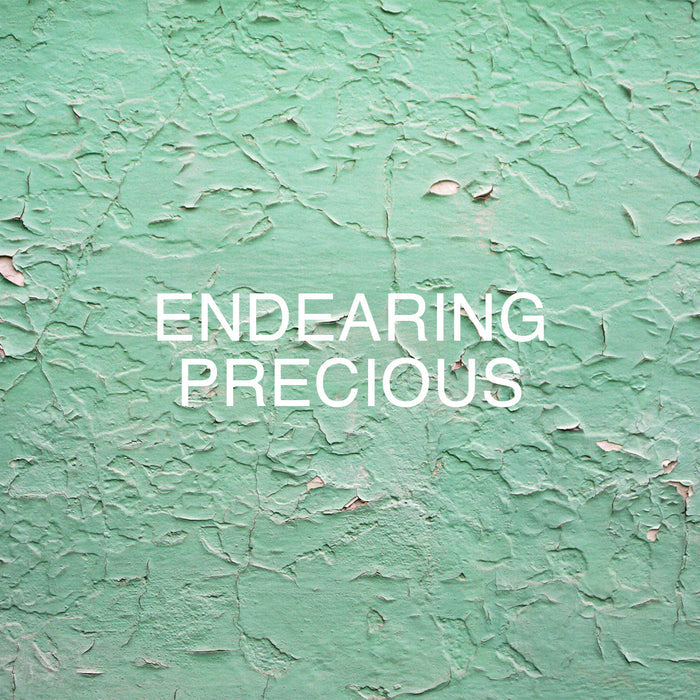 Text on a textured green wall reads "Endearing Precious." The surface appears weathered and peeling.