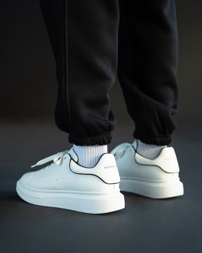 Martin Valen men's chunky white sneakers with black heel line, rear three-quarter on-foot view highlighting the black heel trim.