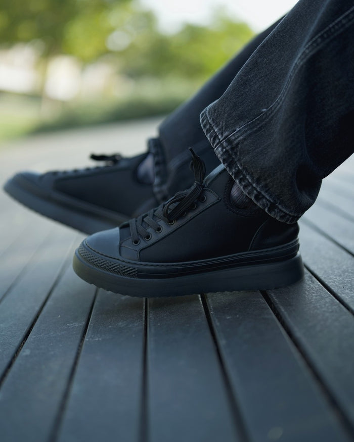 Martin Valen MonoFlux high-sole black scuba fabric sneakers, on-foot side view in grey jeans outdoors showing raised platform sole