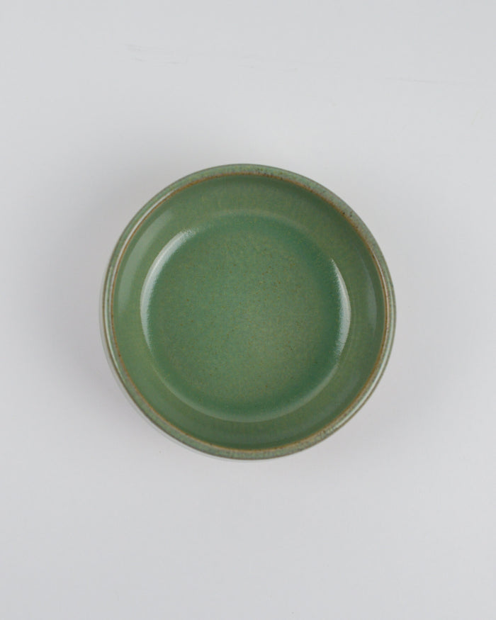 Green ceramic dipping bowl on a white background