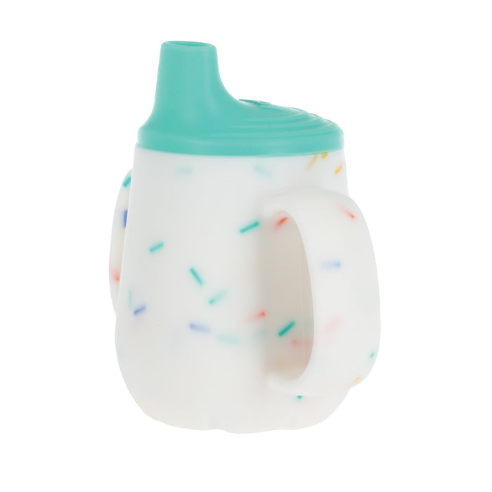 The 2-Handle First Training Cup | Aqua Confetti features a white silicone body, teal free-flow spout lid, two handles, and colorful sprinkle-like dots for an easy grip.