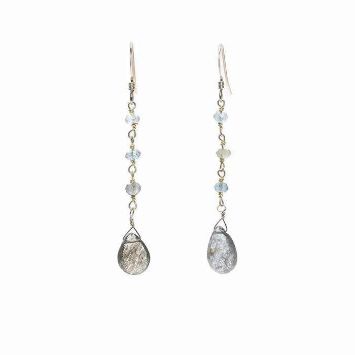 Pair of delicate drop earrings featuring light blue gemstones and teardrop-shaped metallic stones, called Alice Gemstone Earrings | Liv & B.