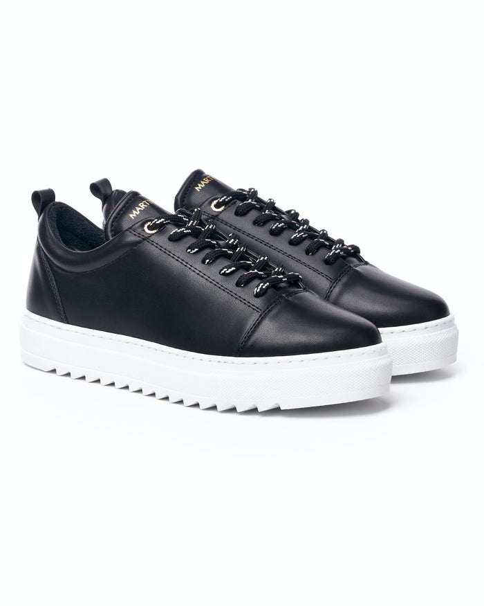 Martin Valen Artestitch pair of low-top black sneakers, close top view showing black-and-white laces and branded tongue