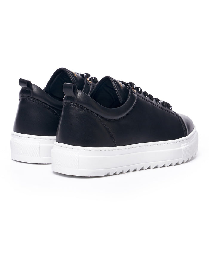 Martin Valen Artestitch men’s low-top black sneakers, three-quarter front view showing rounded toe and thick white sole