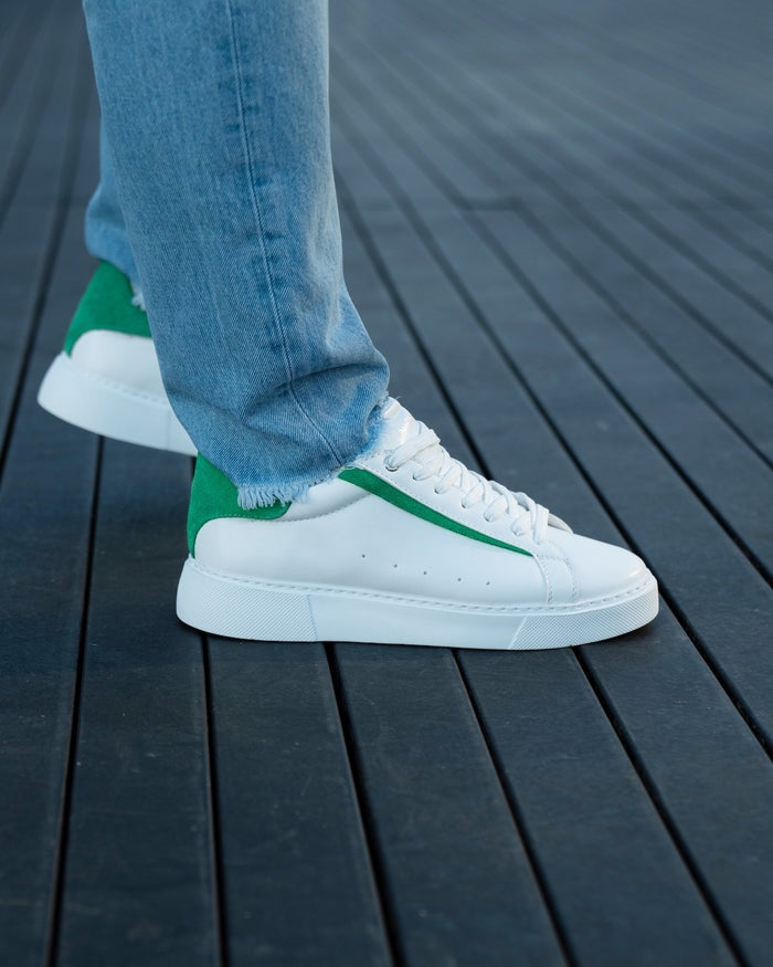 Martin Valen Axino men's white casual sneakers, side view with green heel detail and worn with jeans