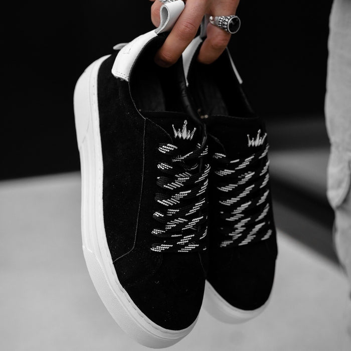 Martin Valen Bobe black and white suede sneakers, hand-held close-up showing patterned laces and crown logo on tongue