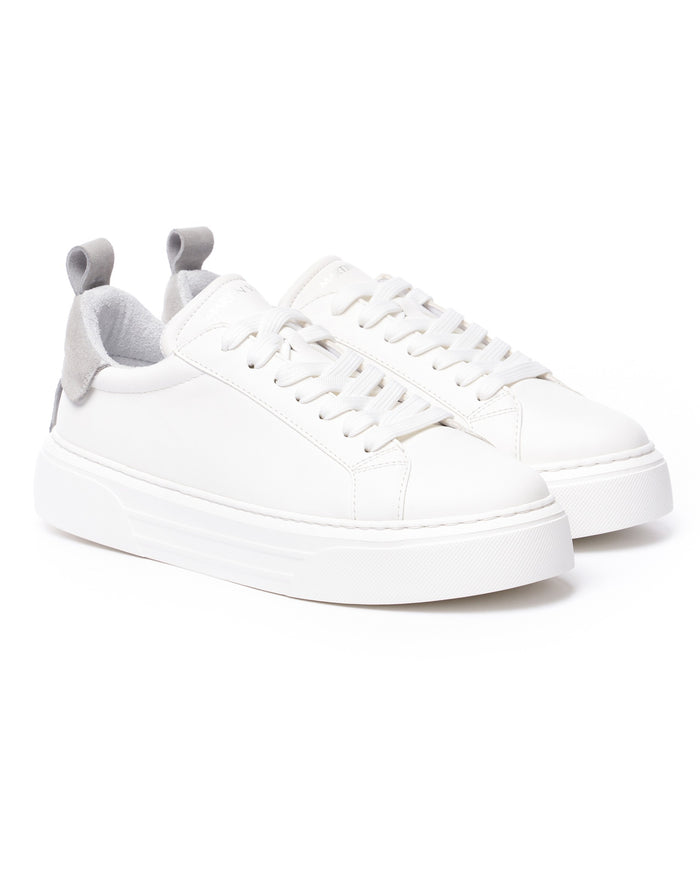 Pair of Martin Valen Bobe white sneakers, angled front view showing laces and grey suede heel tabs with raised sole
