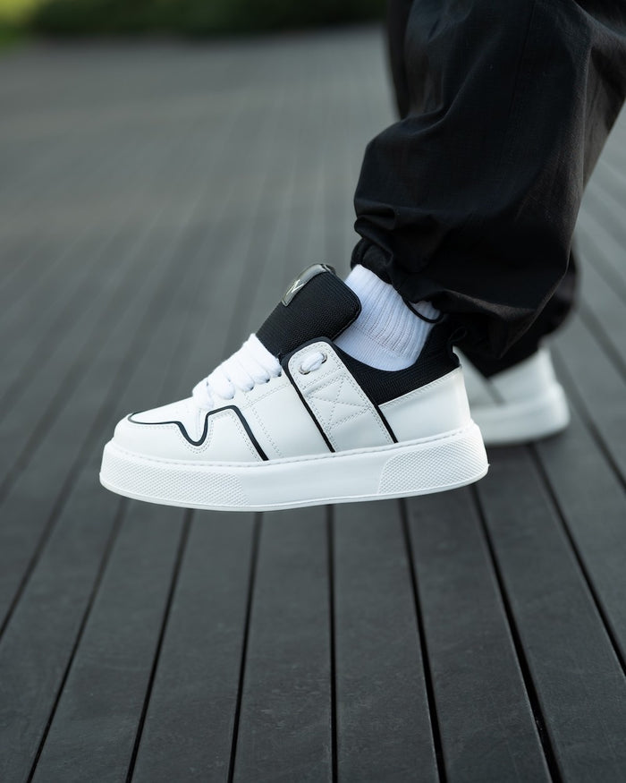 Martin Valen chunky white sneakers mid-air side view showing black tongue and visible eyelet detail