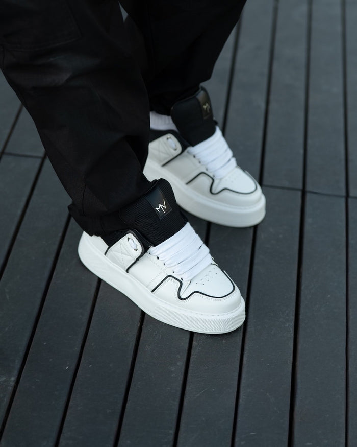 Martin Valen pair of chunky white sneakers three-quarter view with black lines and black tongue, laces visible