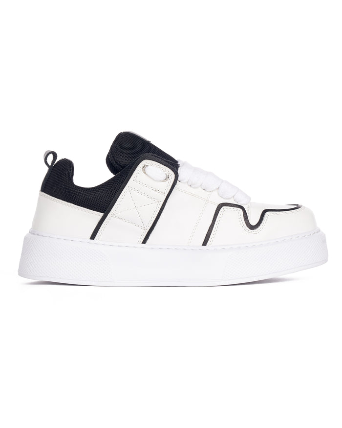 Martin Valen close-up of black tongue with 'MV' logo and eyelet, white laces visible, angled crop