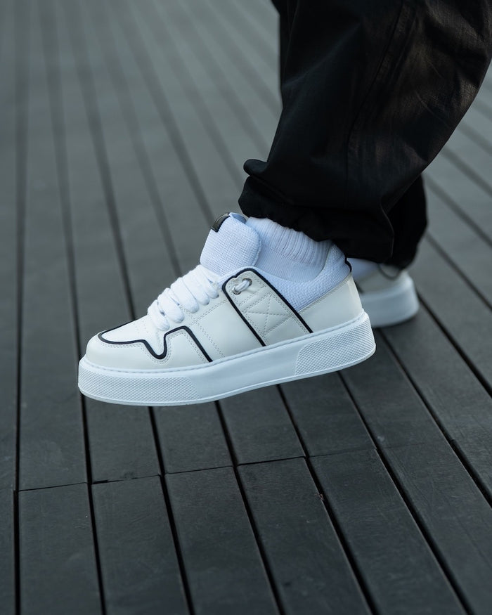 Martin Valen bulky white sneaker side view on a raised foot, black contrast line and thick platform sole
