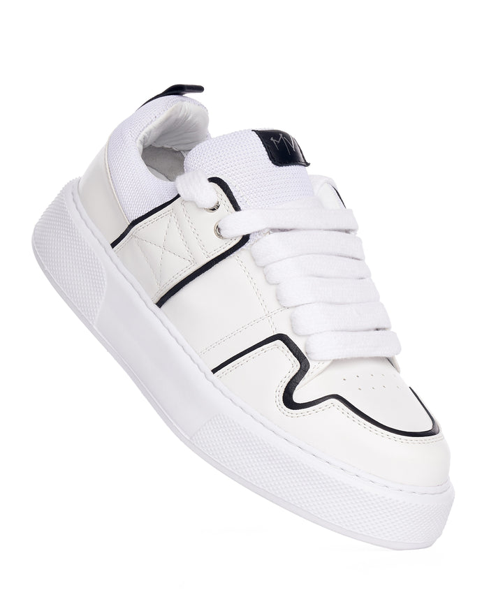 Martin Valen chunky white sneakers with black line, top-side angle showing metal eyelets and contrast stitching