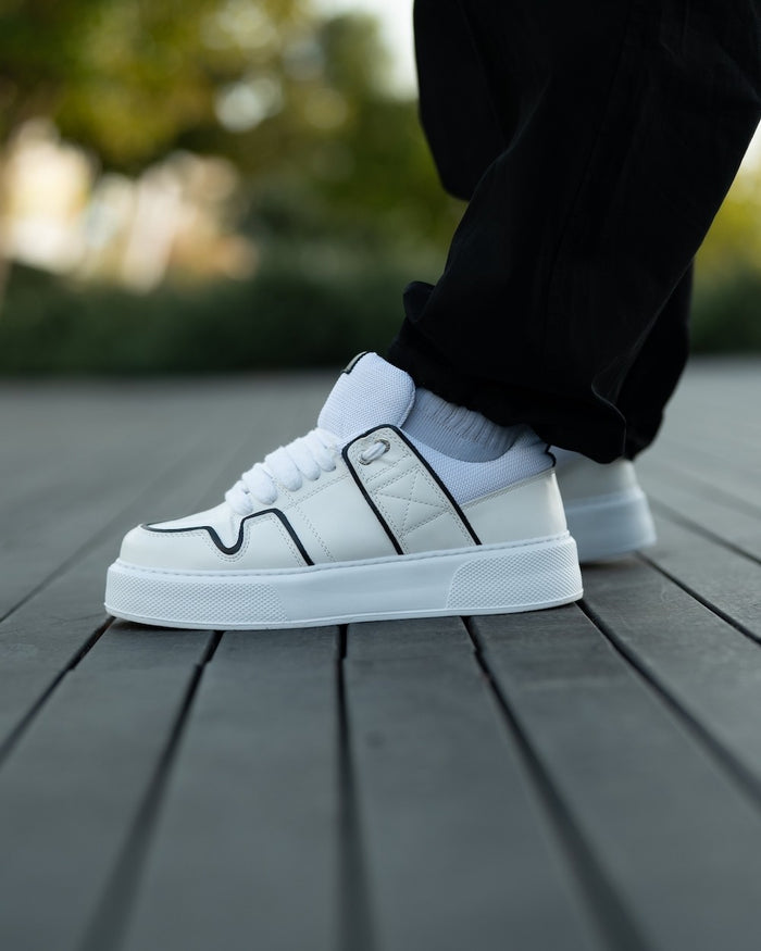 Martin Valen chunky white sneakers with black line, angled front-side view showing thick laces and black trim on the upper