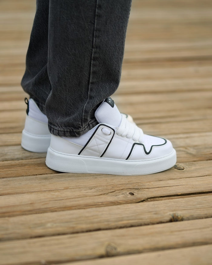 Martin Valen chunky white sneakers close side view, showing strap detail and black trim outline