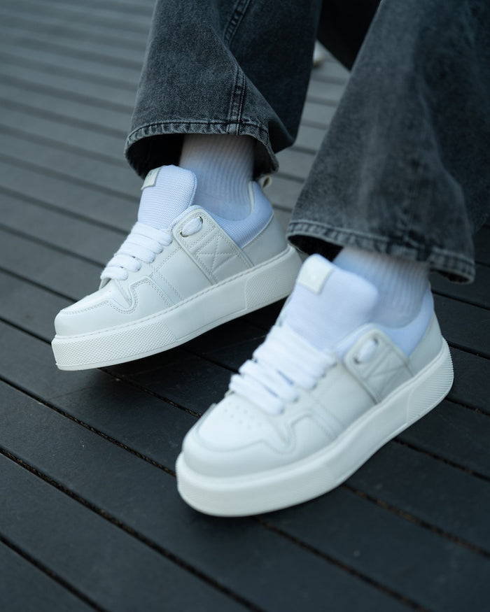 Martin Valen bulky white sneakers, close side view showing platform sole and quilted detail near the eyelets, laced and worn.
