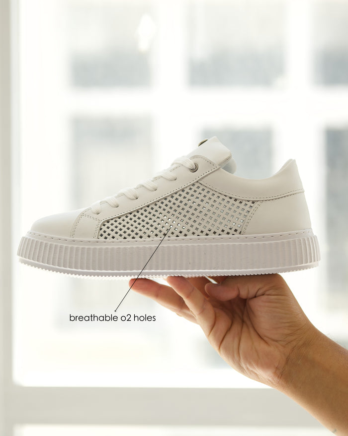 Martin Valen white mesh leather casual sneakers, side view held by hand showing perforated panels and ribbed platform sole