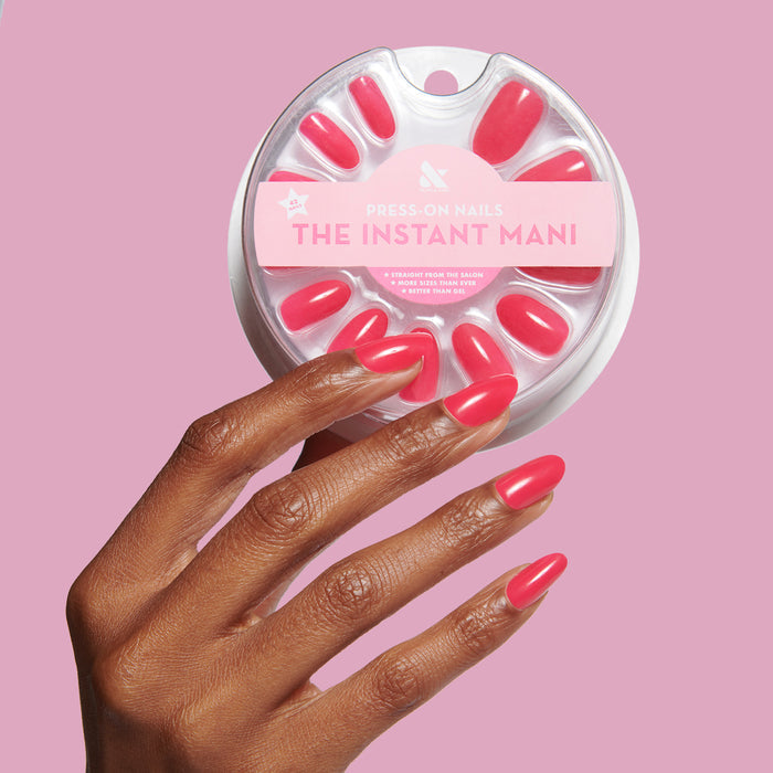 Hand displaying Cherry Crush | Oval | Medium press-on nails in bright cherry red with neon pink finish holding matching set