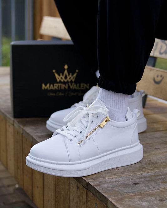 Martin Valen white chunky sneakers side view on foot with visible gold zipper and branded box in background