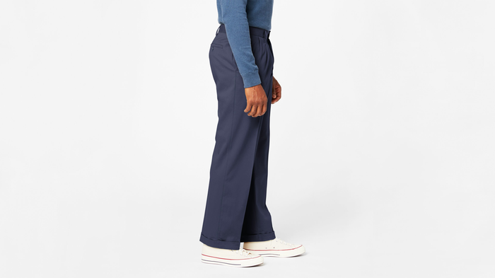 Side view of model wearing Navy Comfort Khakis, Pleated, Relaxed Fit.