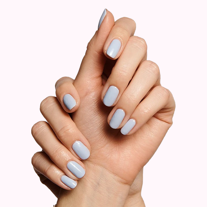 Hands with nails painted in soft pastel blue gel polish showcasing Gift The Mani System manicure quality