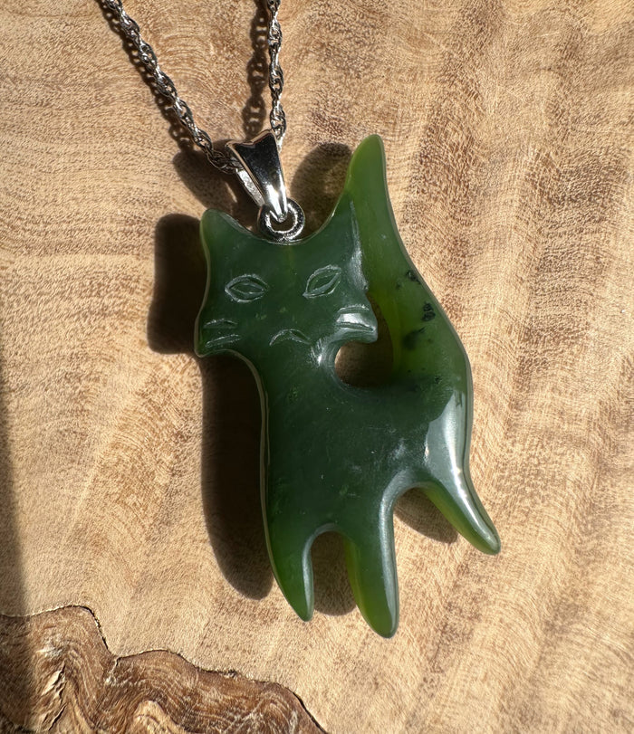Grumpy Canadian Jade Cat Pendant on a silver chain, a green cat shaped pendant with a carved face