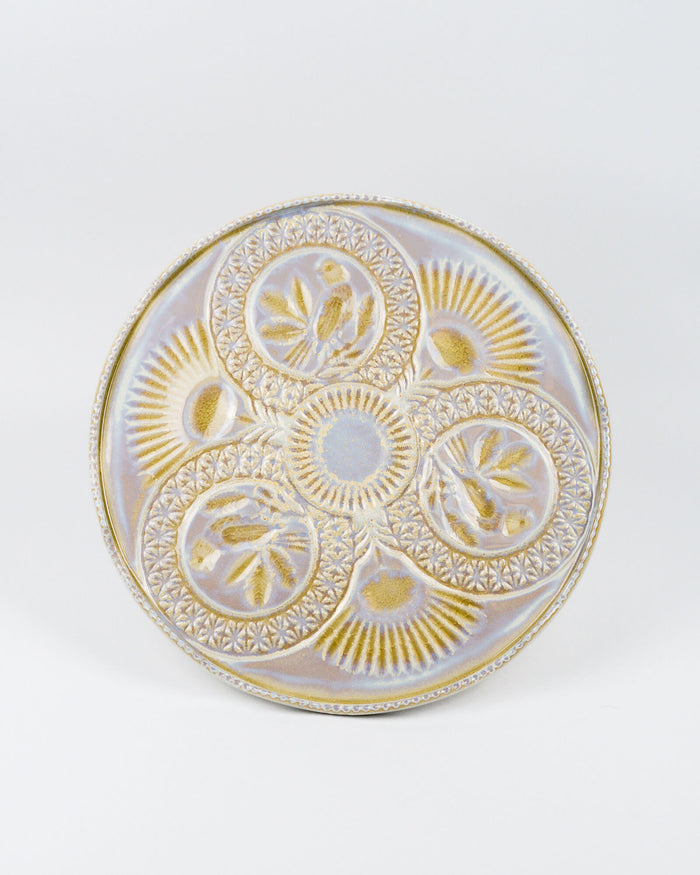 Top view of a decorative cake stand with gold and white patterns on a white background