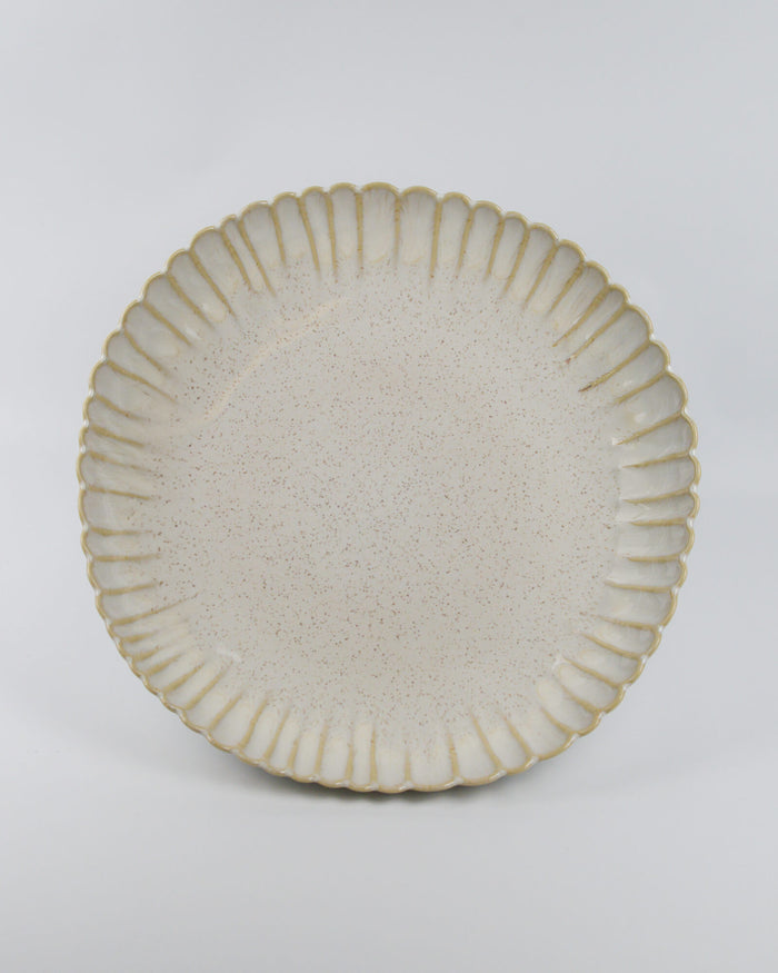 Ceramic serving dish with textured rim on a white background