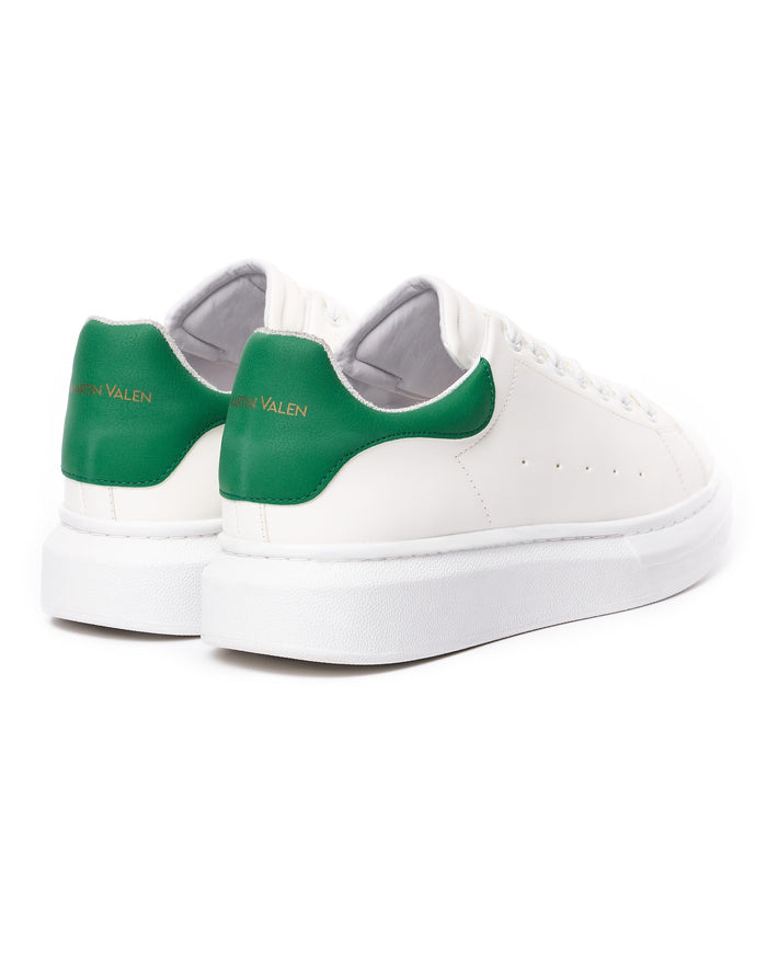 Two Martin Valen white chunky sneakers, side view showing green heel tabs and thick platform sole