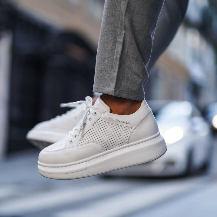 Martin Valen men's white sneakers, close side view mid-jump showing perforated side panel