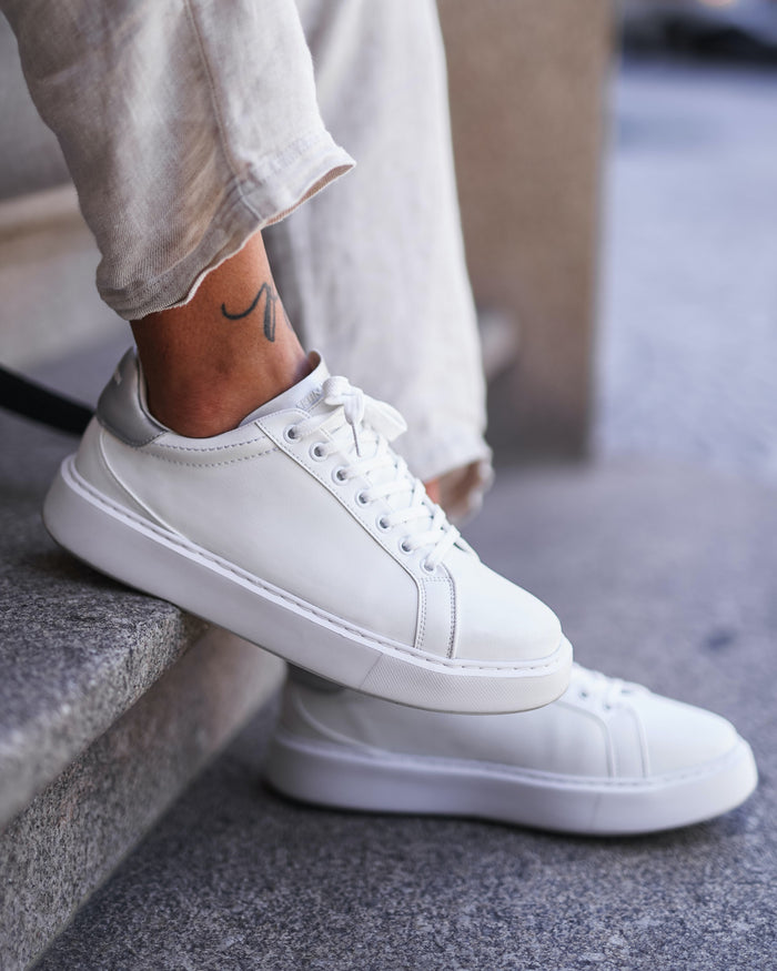 Martin Valen Iconic men's white-grey sneakers close-up on foot, side angle showing laces and silver-grey heel detail.