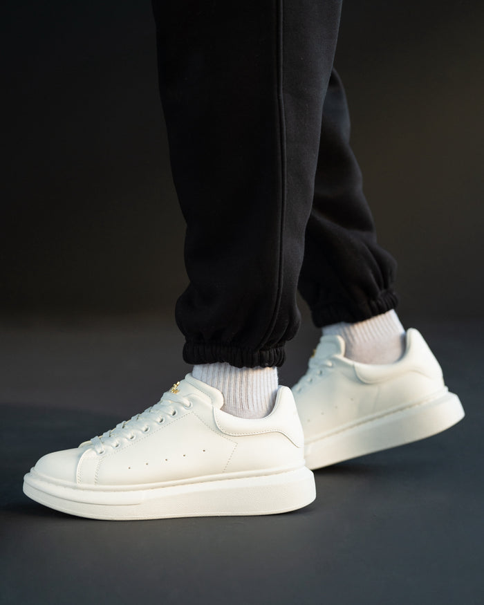 Martin Valen white chunky sneakers worn, low side view showing thick sole and gold crown on the tongue