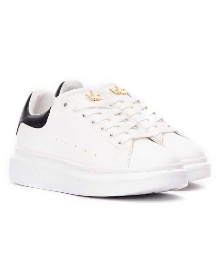 Martin Valen close side view of white sneaker with black heel, perforations on the side and high sole visible