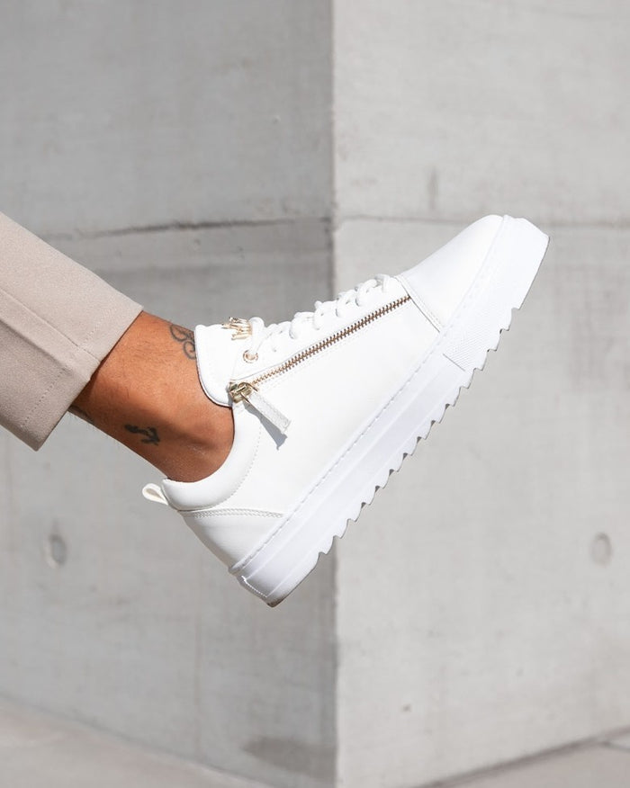 Martin Valen men's low-top white sneaker worn side view, angled profile highlighting gold zipper and chunky ridged platform sole