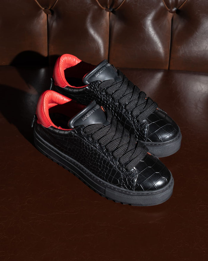 Pair of Martin Valen men's low-top black sneakers with red lining, overhead view showing crocodile-embossed pattern and thick laces