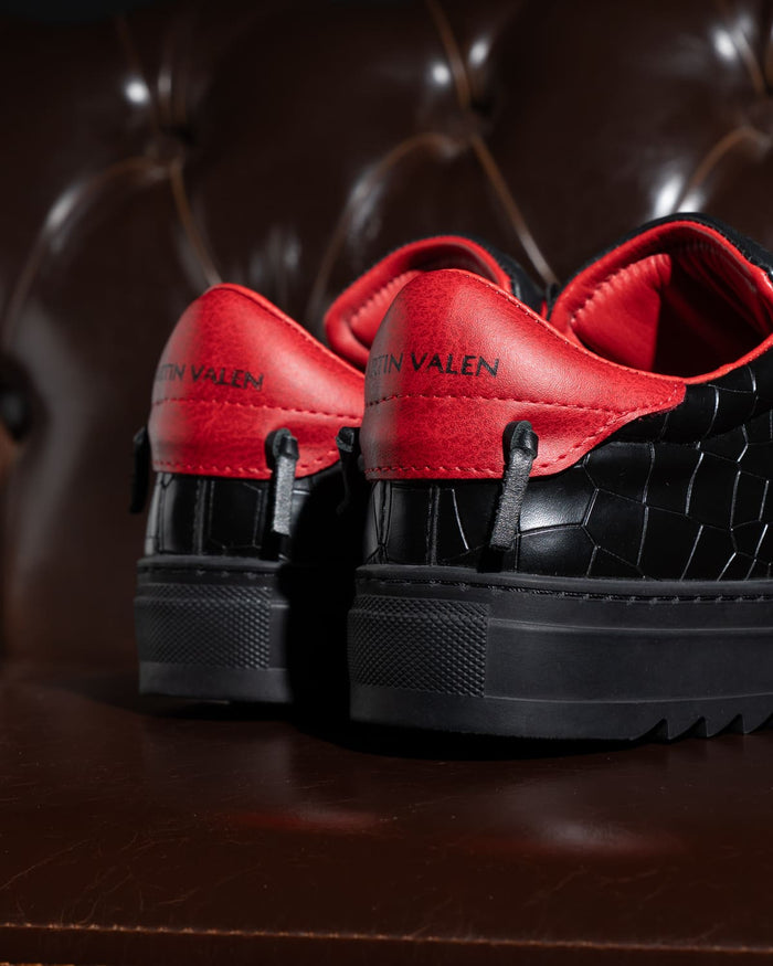 Martin Valen men’s low-top sneakers rear close-up showing red heel tab, black croc-textured upper and chunky black sole.