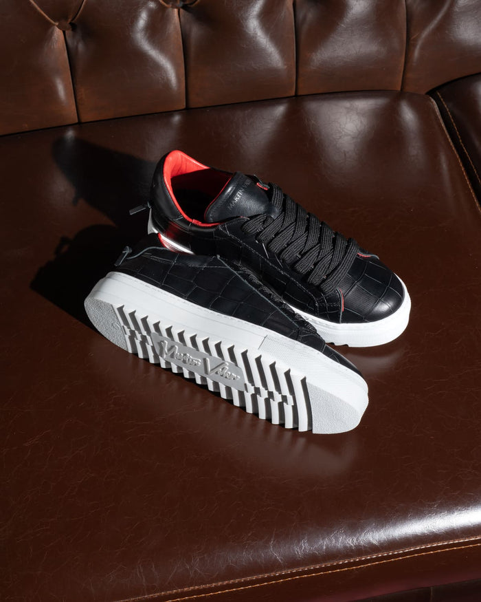 Martin Valen men's low-top black-and-white sneakers, three-quarter top view showing white platform sole and red lining