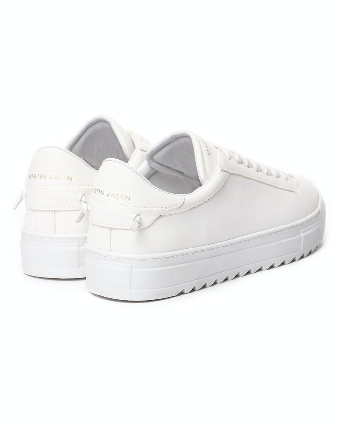 Martin Valen men's low-top white sneakers, rear-quarter view showing gold Martin Valen logo on heel tab and serrated outsole