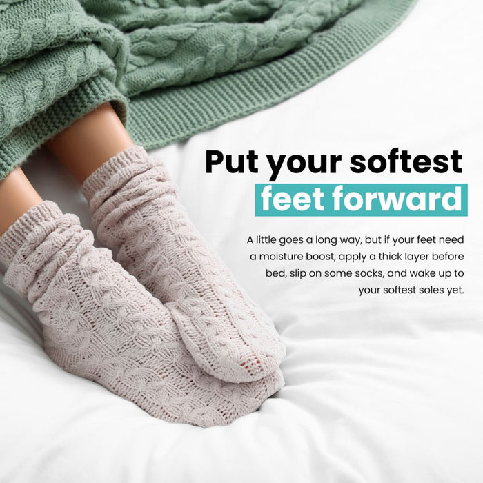 Close-up of feet in cozy knitted socks on a white bed with a green blanket, alongside text about LONDONTOWN's Mini Foot Balm and tips for softer feet.