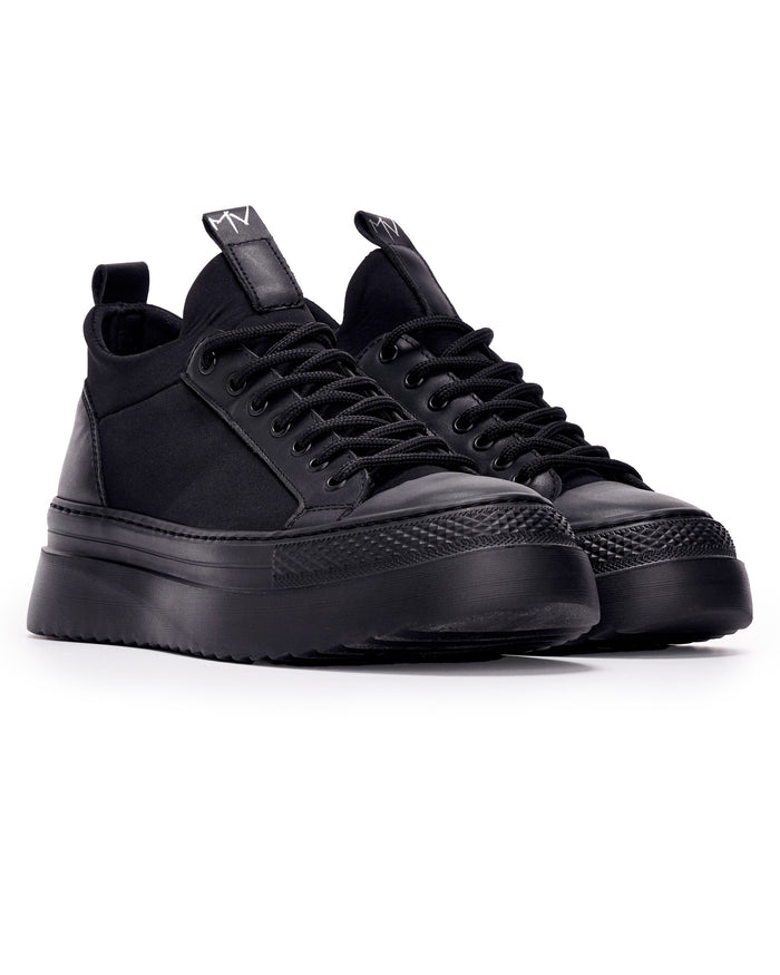 Martin Valen MonoFlux high-sole black scuba fabric sneakers, front three-quarter view showing rounded black toe caps and thick platform soles