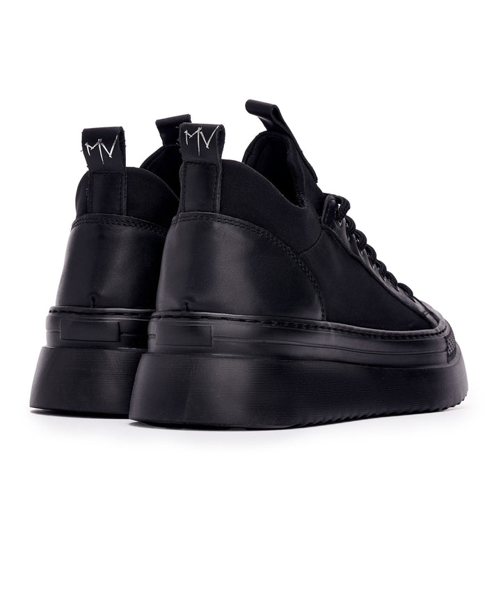Martin Valen MonoFlux high-sole black scuba fabric sneakers, rear three-quarter view showing MV heel pull tabs and chunky platform sole