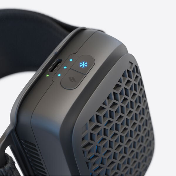 Close-up of a sleek black recovery tool featuring a ventilation grille and control buttons with LED indicators, designed for body care and wellness using the RecoveryTherm Cube | Therabody.