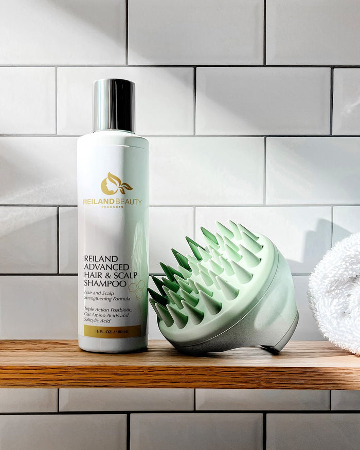 Reiland Advanced Hair & Scalp Strengthening Shampoo with Free Scalp Massager – 6 fl. oz. bottle. Triple Action Postbiotic formula with Oat Amino Acids and Salicylic Acid. Promotes healthy hair growth, clears buildup, and soothes dry scalp.