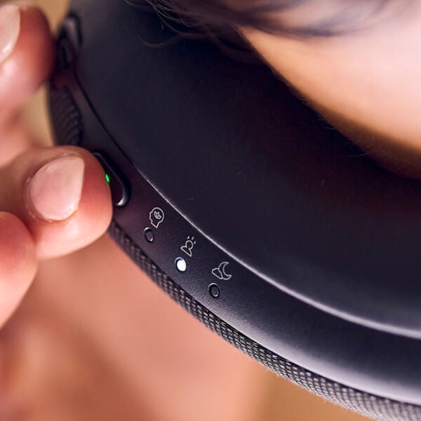 Close-up of a person adjusting controls on the black SmartGoggles 2 | Therabody, a wellness device designed for relaxation and recovery.