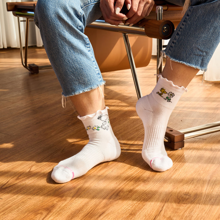 White quarter compression socks with floral designs and lettuce edge, worn with cropped denim jeans.