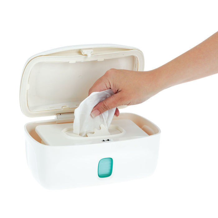 A hand pulls a wet wipe from the Nuby Wipe Dispenser, a white plastic box with a weighted plate, open against a white background—ideal for quick diaper changes.